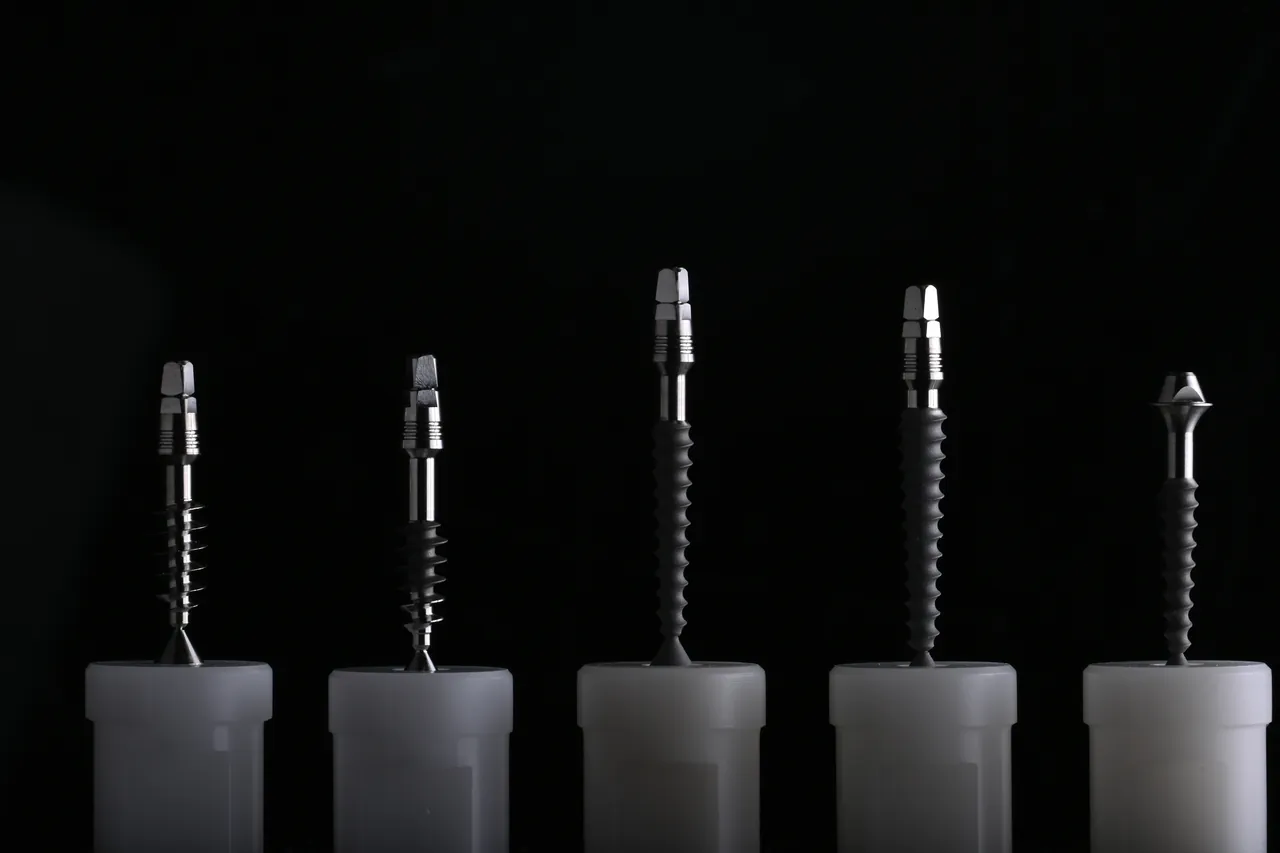 Five Monoimplant one-piece implants photographed on black